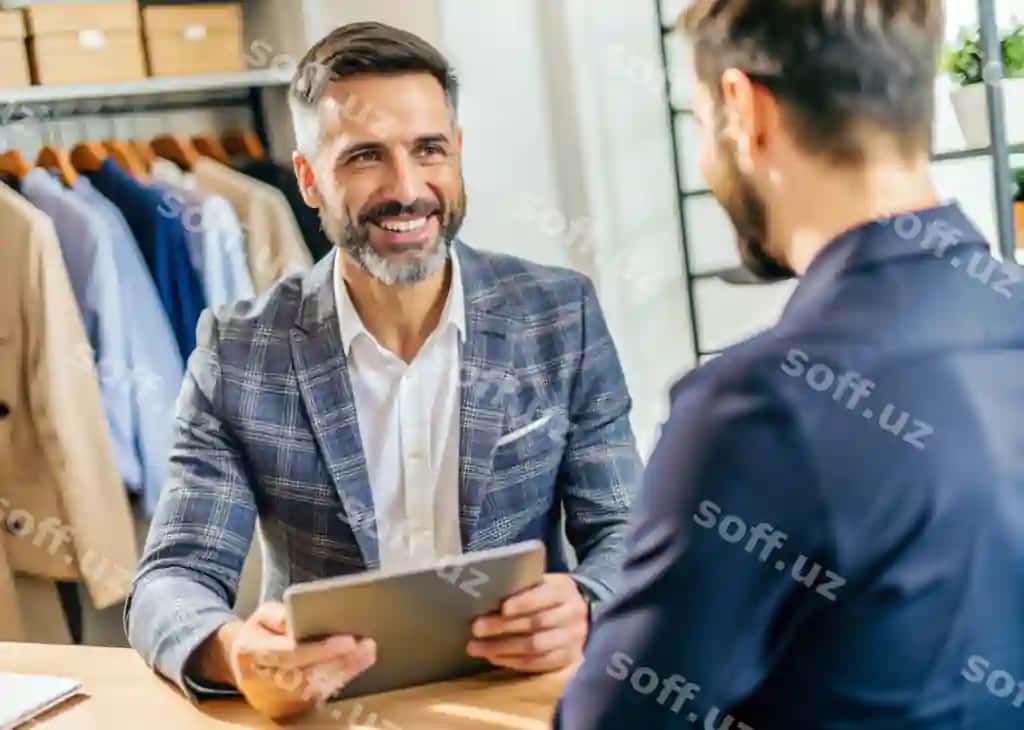 Erkak erkak kostyumida tabletga qarayotgan holda gulmoqda. | Man is smiling while looking tablet with man suit